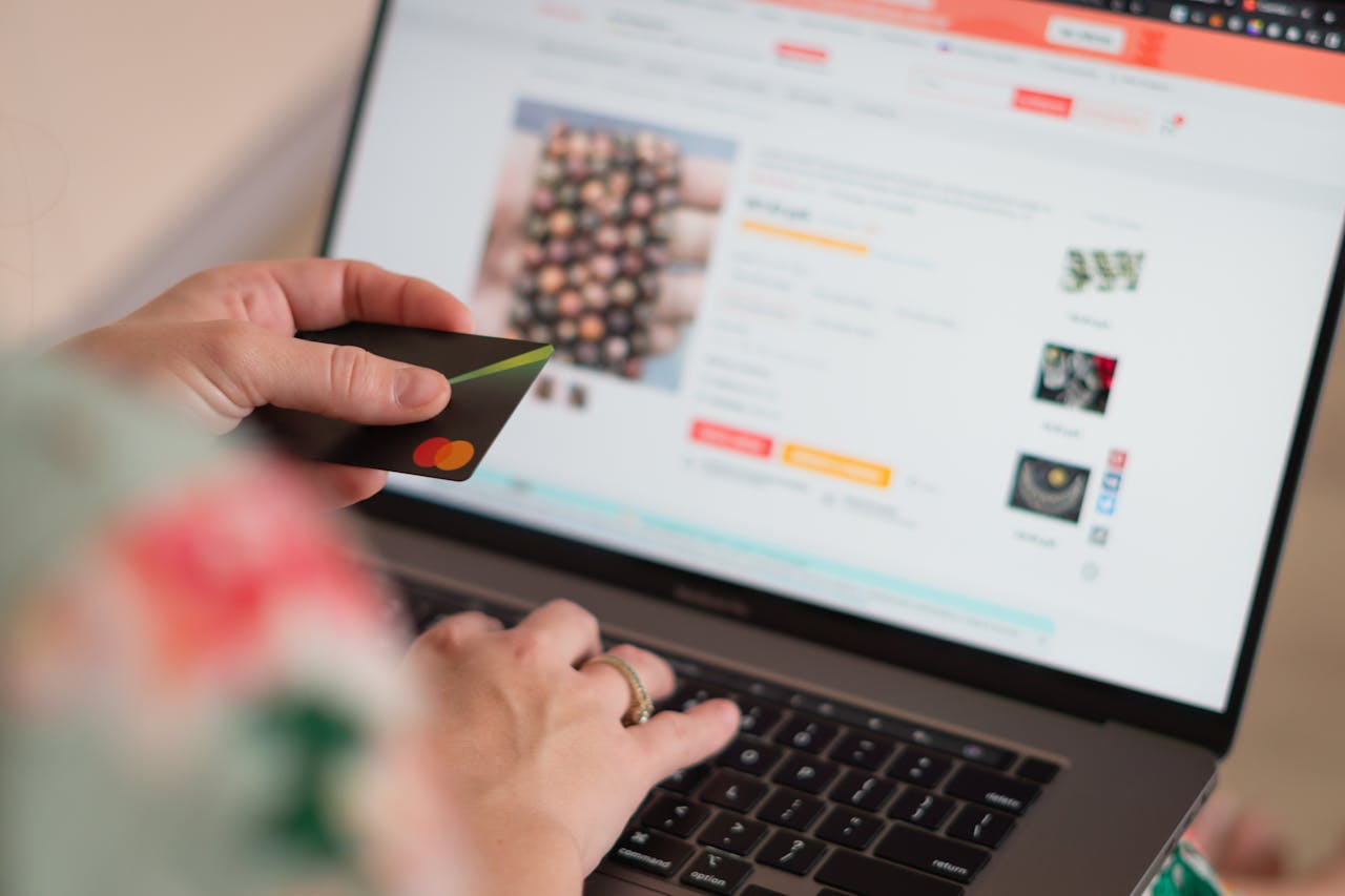 contact-img Engaging in online shopping using a credit card with a laptop for convenience and ease.
