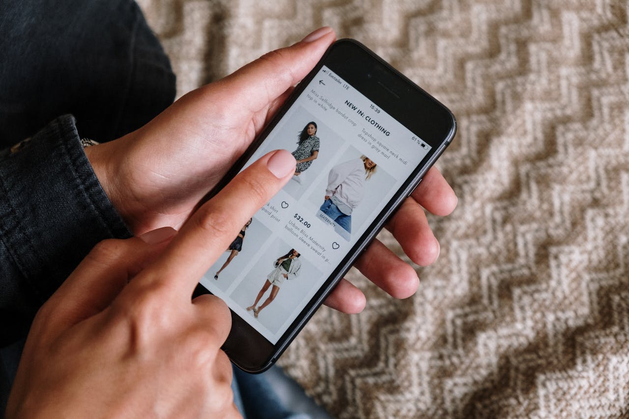 gallery-2 Person browsing clothing items on a smartphone, showcasing modern online shopping experience.