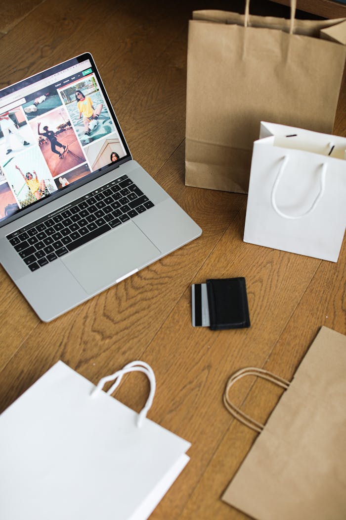 services-img Laptop with shopping bags and a credit card on a wooden floor, symbolizing online shopping.